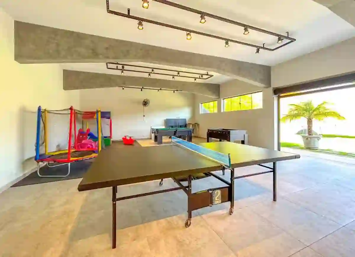 Salão de jogos com mesa de ping pong e pebolim